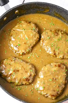 meatballs covered in gravy and sprinkles in a skillet