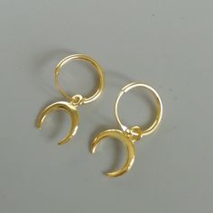 A PAIR of sterling silver hoops with a detachable moon phase charm. This piece is plated in gold. The charm is multipurpose and can be used with a neck or bracelet chain too. Dimension: Hoop- 12x1 mm Charm- 10 x 12 mm Drop length- 22mm This piece is made of 925 hypoallergenic sterling silver, plated in gold. Price listed is for a PAIR of hoops. Can be packaged in a gift box. I can include a personal message from you if needed You are welcome to contact me at... bhavnakwintra1956@gmail.com For mo Gold Hoop Jewelry With Moon Phase Detail, Silver Brass Small Hoop Huggie Earrings, Celestial Hoop Earrings With Ear Wire, Minimalist Sterling Silver Hoop Earrings With Moon Charm, Bohemian Gold Hoop Earrings With Moon Charm, Adjustable Hoop Moon Charm Jewelry, Adjustable Moon Charm Hoop Earrings, Adjustable Hoop Earrings With Moon Charm, Hoop Earrings With Moon Charm