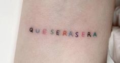 a woman's arm with the word quesera tattooed on her left side