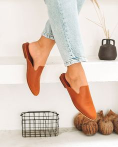 Chic Leather Footbed Slip-on Mules, Modern Brown Slip-ons For Fall, Leather Slip-ons With Almond Toe For Fall, Casual Faux Leather Slip-ons With Leather Sole, Trendy Brown Slip-on Mules, Leather Pointed Toe Mules, Leather Slip-on Slippers For Spring, Brown Slip-on Mules For Fall, Spring Slip-on Mules With Leather Sole