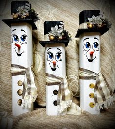 three snowmen with hats and scarves on their heads