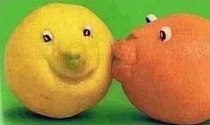 two oranges with eyes and noses are next to each other on a green background