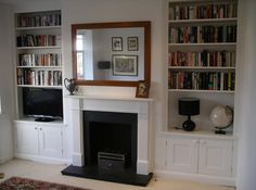 a living room filled with furniture and a fire place under a large mirror on top of a book shelf