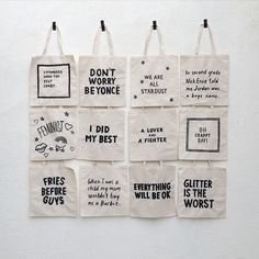 six tote bags hanging on the wall with different sayings and phrases printed on them