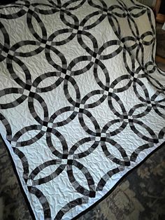 a black and white quilt sitting on top of a bed