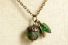 A rich green colored glass crystal with a earthy, mottled finish has been designed into a shimmering evergreen acorn pendant when combined with a detailed bronze leaf charm and dark green glass leaf charm in this handmade acorn necklace. If you would like a length of chain different than offered, please contact me for pricing. Check out the other colors if acorn necklaces offered in my shop! http://etsy.me/1iMZM8w Stop by and visit http://stumblingonsainthood.etsy.com to see more handmade design Acorn Jewelry, Peacock Ring, Acorn Pendant, Back To School Sale, Acorn Necklace, Valentines Sale, Steampunk Accessories, Bronze Necklace, Holiday Earring