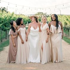 the bridesmaids are all dressed in different styles and colors, posing for a photo