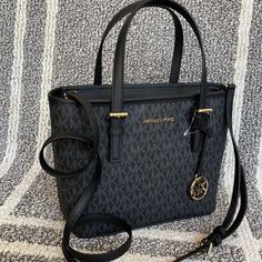 Michael Kors Jet Set Travel Xs Carryall Tote Top Zip Tote Black Color: Black Gold Toned Hardware Zip Top Closure Slip-In Pocket One Mk Charm Custom Fabric Lining 1 Slip-In Pocket, 1 Zipper Pocket 9"(Top) 11"(Bottom) X 7.75" (H) X 4.25"(D) Strap: 5", 24" Michael Kors Black Bag With Top Carry Handle, Mk Bags Michael Kors, Michael Kors Handbags Tote, Michael Kors Black Bags With Handles, Michael Kors Jet Set Large Crossbody Bag, Michael Kors Tote Shoulder Bag With Zipper Closure, Michael Kors Tote Shoulder Bag With Gold-tone Hardware, Carryall Tote, Mk Bags