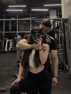 a man and woman taking a selfie in the gym