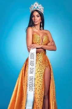 a woman in a yellow dress with a crown on her head and an orange sash around her waist