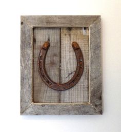 a wooden frame with a horseshoe mounted to it