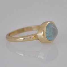 "Beautiful 14k gold ring with blue aquamarine stone for a woman. Elegant gold gift for the woman you love! This 14k gold ring is a perfect, unique, modern ring for every woman. This Aquamarine gold ring is relatively heavy yet maintains a gentle look. The bezel of the ring is intentionally wider than in typical engagement ring bezel, so you can see more gold around the cabochon aquamarine stone. Dimensions: * 14k solid gold * Oval Aquamarine : 8 * 10 m\"m I use natural gemstones in my jewelry wh Simple Gemstone Engagement Rings, Gold Ring With Stone, Aquamarine Gold Ring, Stone Gold Ring, Beautiful Gold Rings, Ring With Stone, Bezel Engagement Ring, Solid Gold Bracelet, Opal Ring Gold