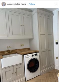 a washer and dryer sitting in a kitchen next to white cupboards on the wall