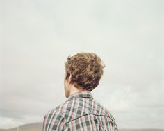 a man in plaid shirt looking out at the sky