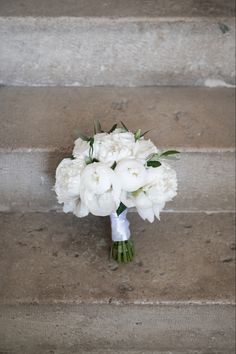 a bouquet of white flowers sitting on some steps