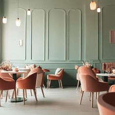 an empty restaurant with pink chairs and green walls