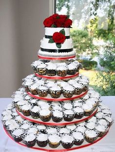 a tiered cake with cupcakes and roses on it