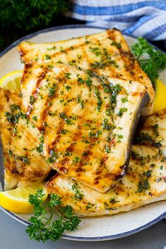 grilled fish with lemon and parsley on a plate