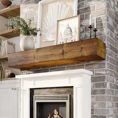 a fire place in a living room with pictures on the mantle and shelves above it