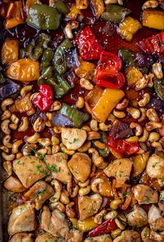 a pan filled with chicken, peppers and cashews