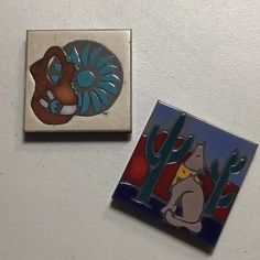 two tile magnets depicting cartoon characters on a white surface with cactus and cat in the background