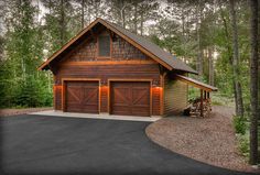 a two car garage in front of a wooded area