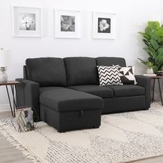 a living room with a black couch and white rug