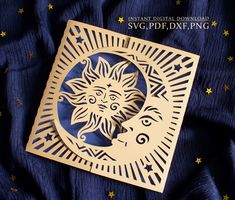 an intricate laser cut out of the sun and moon on a blue background with stars