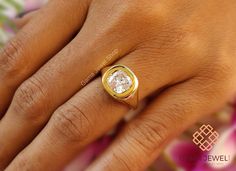 a woman's hand with a yellow gold ring on it and a white diamond in the middle