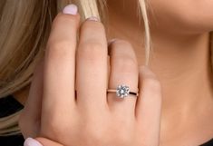 a close up of a person wearing a ring with a diamond on it's finger