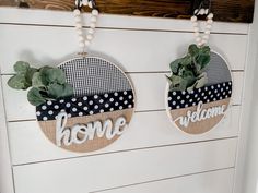 two wall hangings decorated with plants and the words home