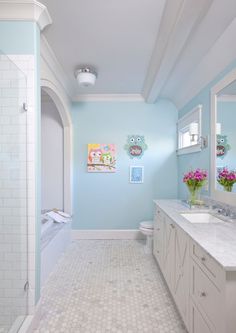 a bathroom with blue walls and white tile on the floor, along with a walk in shower