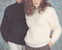 two people standing next to each other wearing sweaters