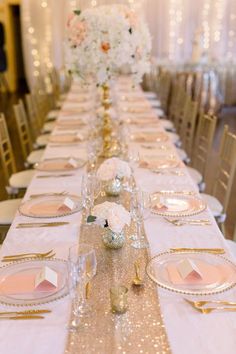 the table is set with pink and gold place settings