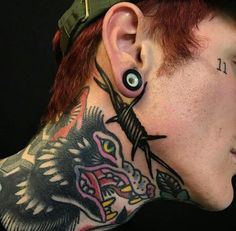 a man with tattoos on his face and neck