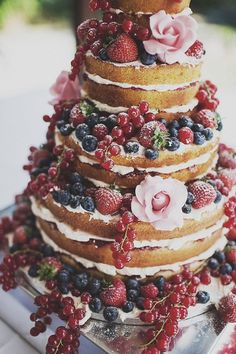 the wedding cake is decorated with fresh berries and flowers