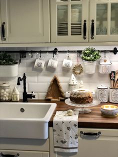 a kitchen with white cabinets and wooden counter tops, including a cake on a cutting board