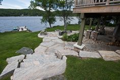 an outdoor patio with stone steps leading to the water