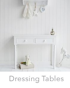 there is a white table with flowers on it and the words dressing tables above it