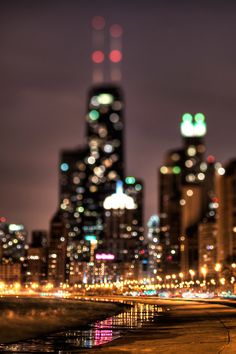 the city skyline is lit up at night with lights reflecting in the water and buildings