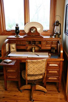 an old fashioned desk and chair in front of a window