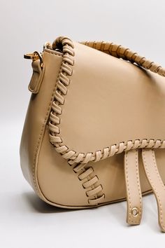 The Sloane Sand Leather Braided Strap Purse, a fusion of sophistication and artisanal craftsmanship. Crafted from luxurious tan leather fabric, this purse exudes timeless elegance and understated charm, making it a versatile addition to any wardrobe. The standout feature of this purse is its intricate Braided Details, meticulously crafted to add texture and visual interest to its classic design. Each braid speaks to the meticulous artistry that goes into creating this piece, elevating it to a tr Faux Leather Purse, Studded Necklace, Faux Leather Belts, Travel Dress, Braided Strap, Bar Earrings, Leather Belts, Leather Fabric, Tan Leather