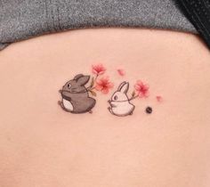 a woman's stomach with two rabbits and flowers on the side, one is in front of the other