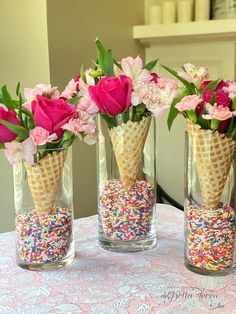 three vases filled with flowers and sprinkles on top of a table