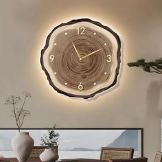 a clock that is on the side of a wall in a living room next to a table and chairs