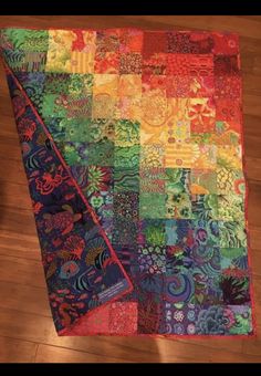 a multicolored quilt is laying on the floor