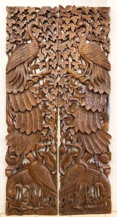 two carved wooden panels with birds on them