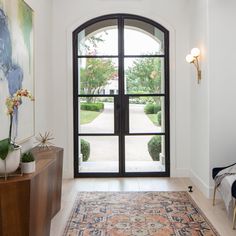 an entry way with a large rug on the floor and two doors leading to another room