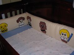 a baby crib with cartoon characters on it's sheets and bumper pad covers