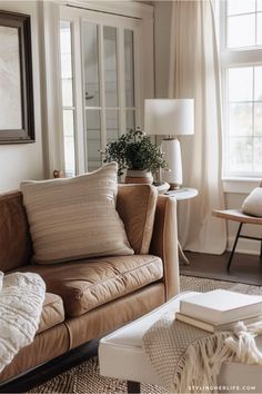 a living room filled with furniture and a painting hanging on the wall above it's windows